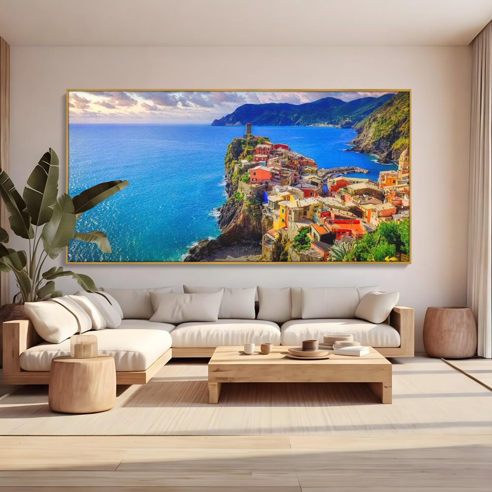 Tablou canvas cu peisaj costier italian cu sat colorat pe stanca, in rama de aluminiu auriu, pe perete intr-un living